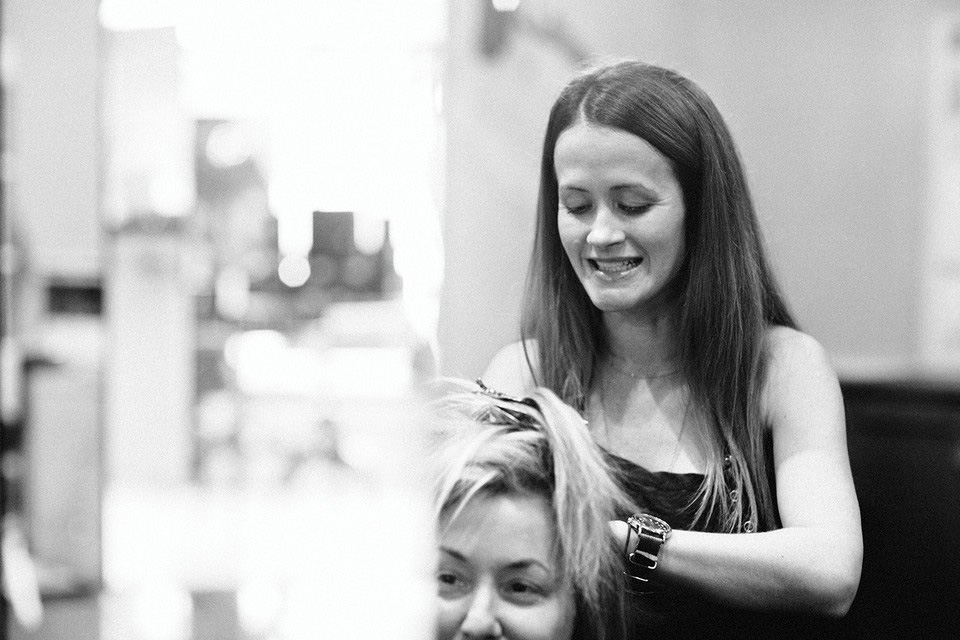 A stylist colors a client's hair in the salon. Photo by Graham Yelton.